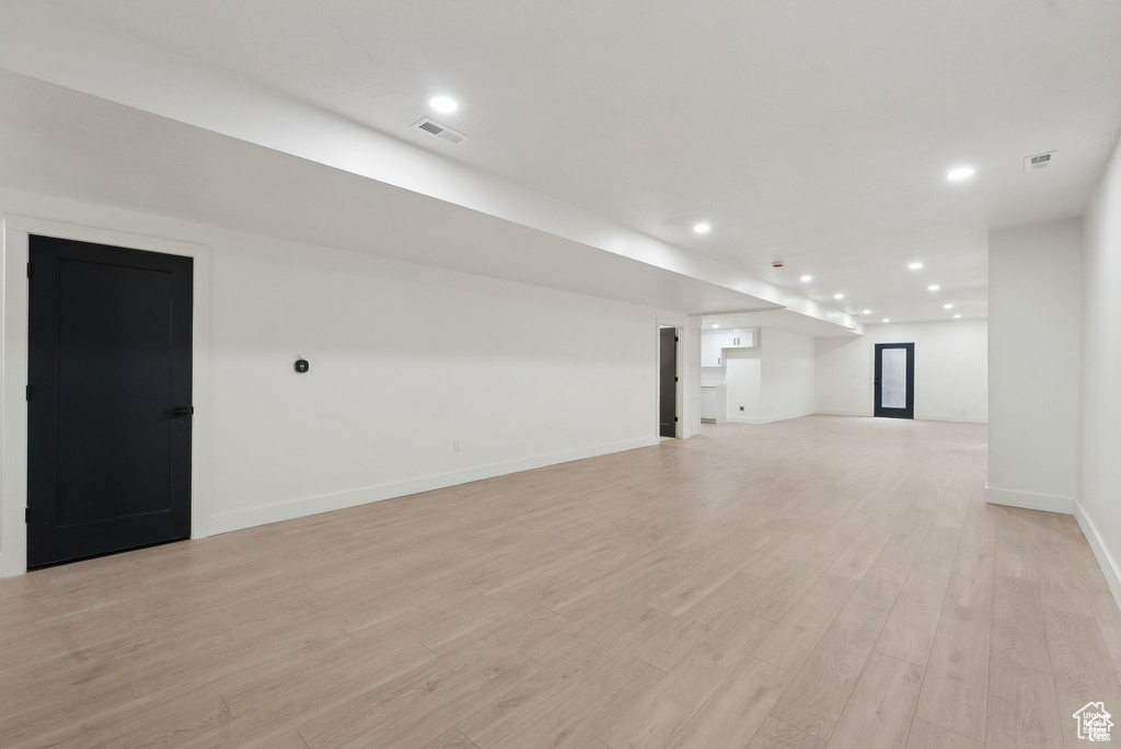 Unfurnished living room featuring recessed lighting, light wood finished floors, and baseboards