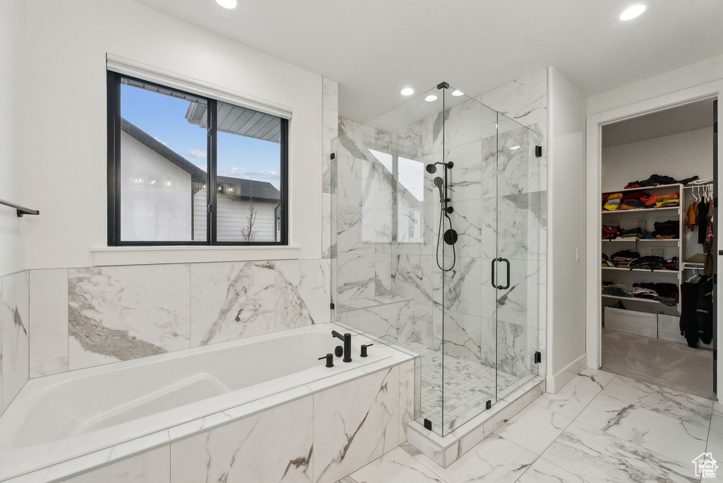 Bathroom with a bath, recessed lighting, a marble finish shower, a walk in closet, and marble finish flooring
