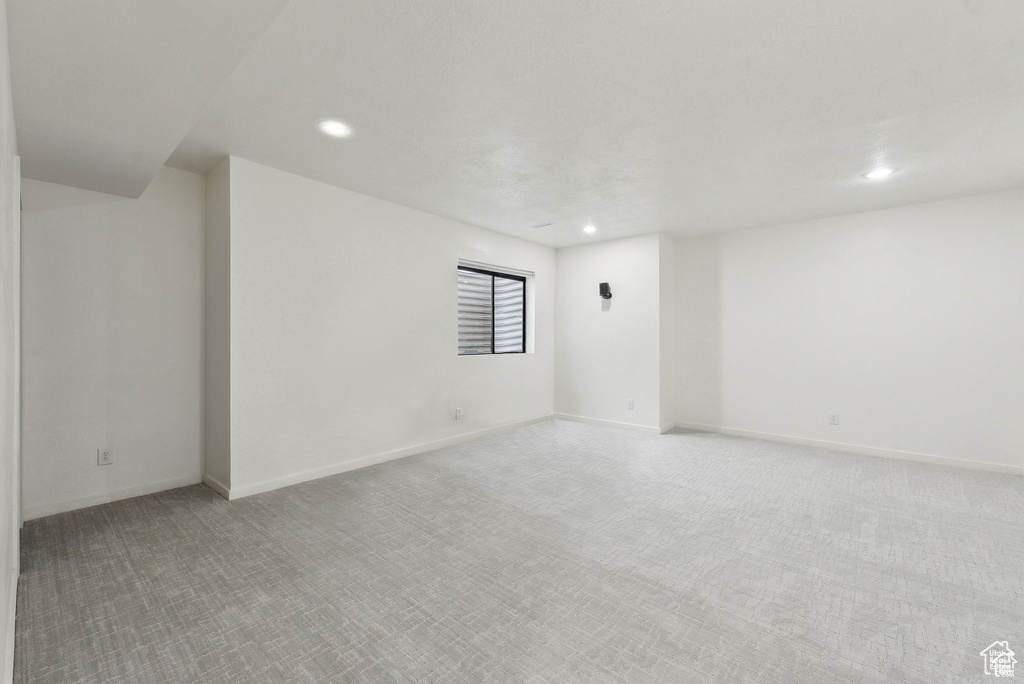 Empty room featuring recessed lighting, light colored carpet, and baseboards