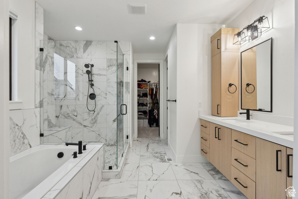 Bathroom with a marble finish shower, a garden tub, double vanity, marble finish floors, and a walk in closet