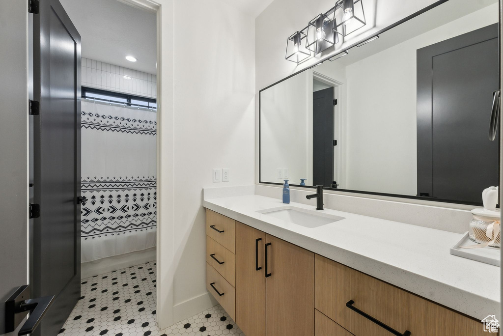Full bathroom with vanity, recessed lighting, baseboards, and curtained shower