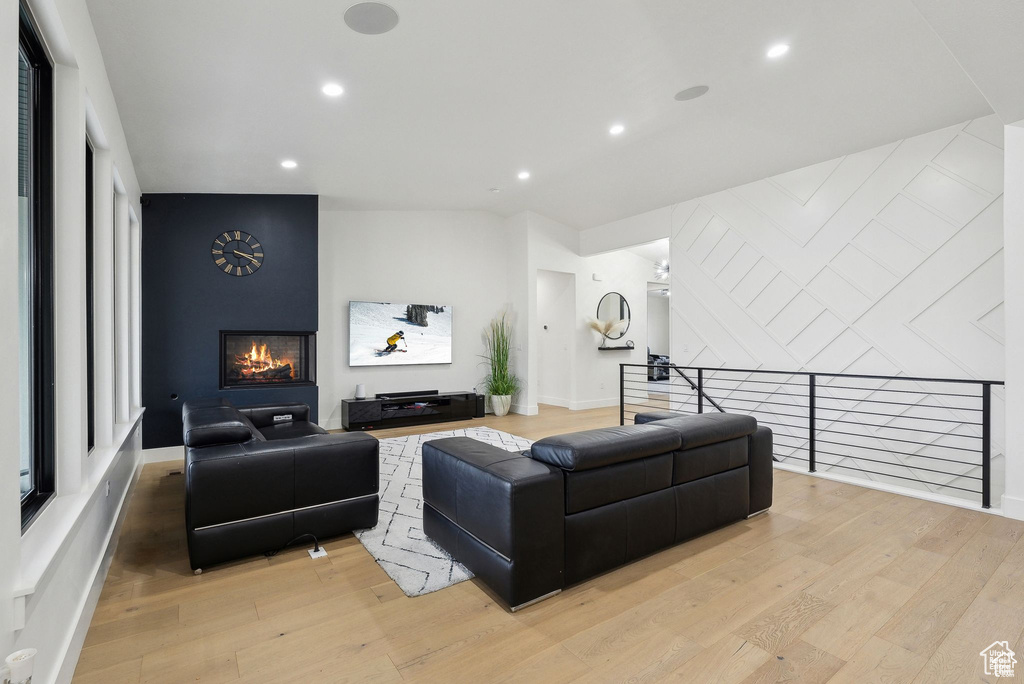 Living area featuring light wood-style flooring, a fireplace, recessed lighting, and baseboards