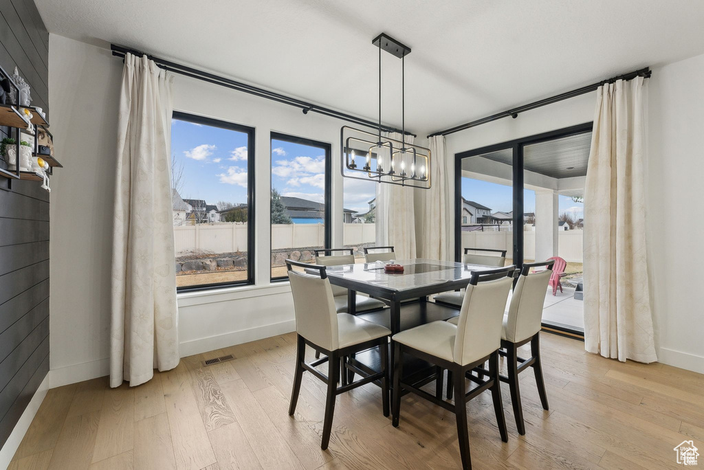 Dining space featuring light wood-type flooring, baseboards, and a chandelier
