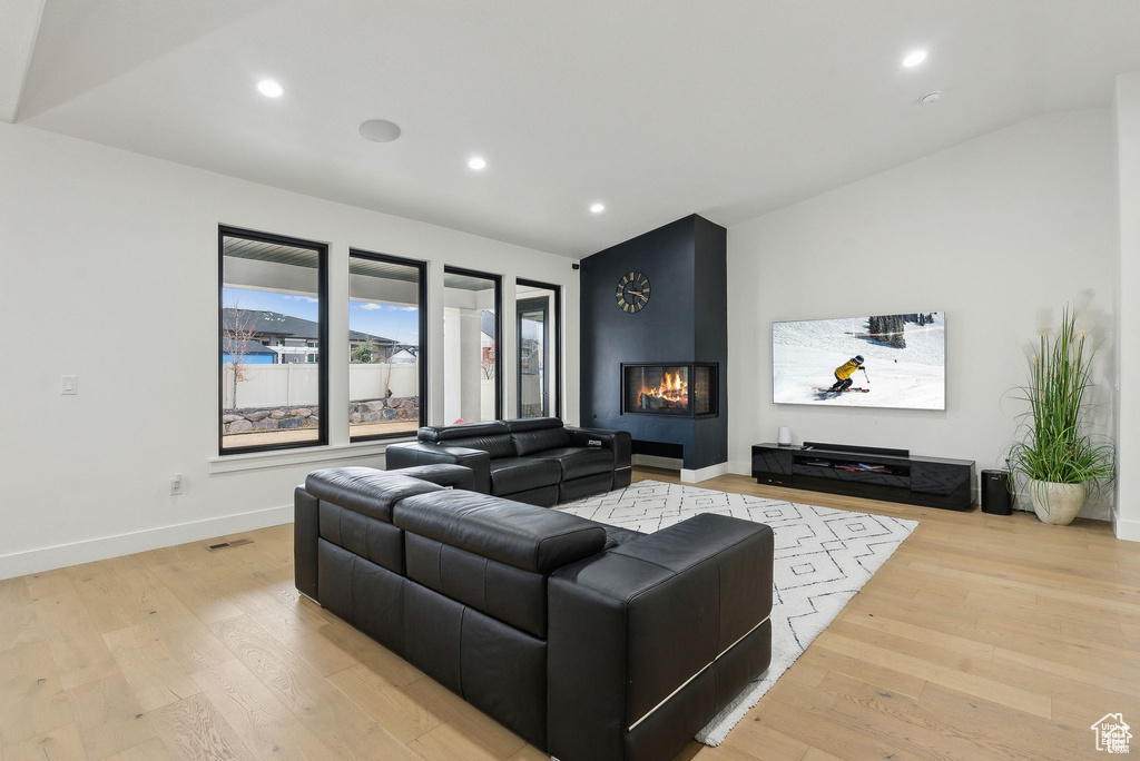 Living area with light wood-style flooring, recessed lighting, baseboards, and a fireplace