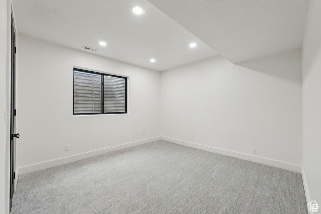 Empty room featuring recessed lighting, light carpet, and baseboards