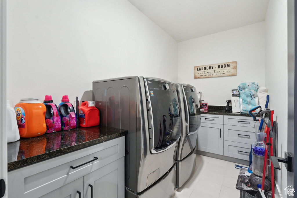 Washroom featuring separate washer and dryer, cabinet space, and light tile patterned floors