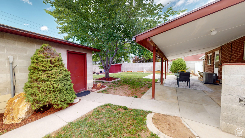 View of yard with central air condition unit and a patio