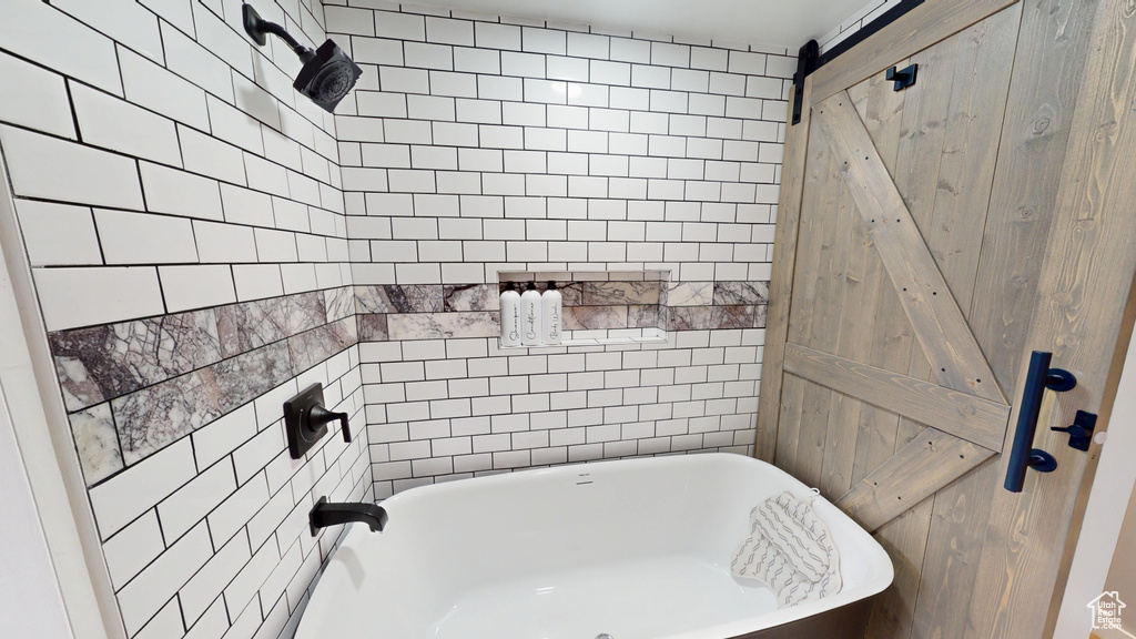 Full bath featuring a freestanding tub and tile walls