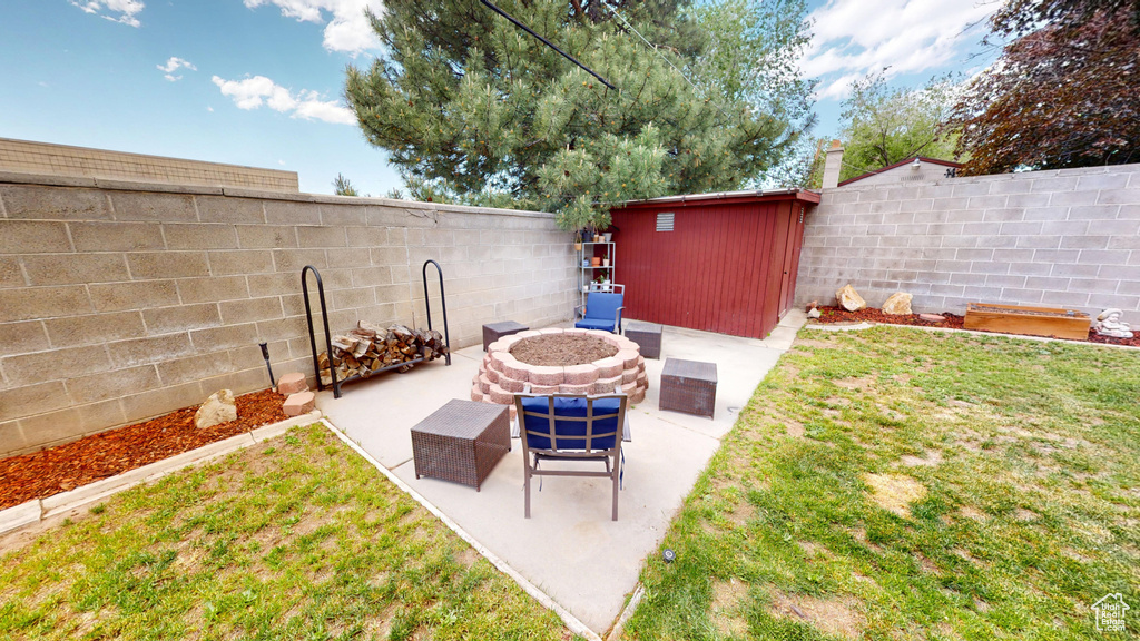 View of patio / terrace with an outdoor fire pit and an outbuilding