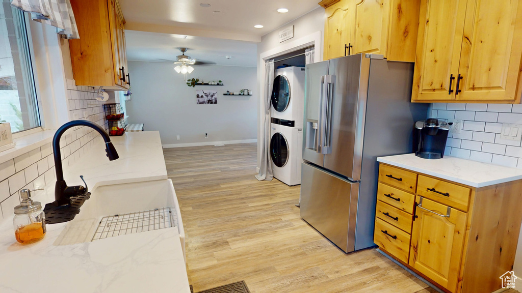Kitchen featuring stacked washer and clothes dryer, light wood finished floors, a ceiling fan, tasteful backsplash, and recessed lighting
