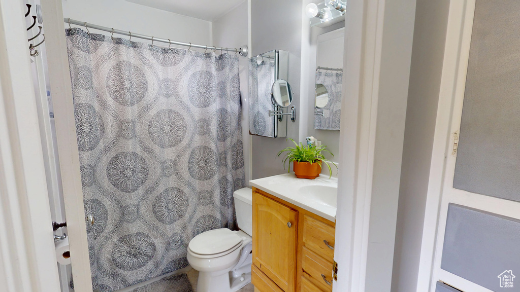 Bathroom with vanity, toilet, and a shower with shower curtain
