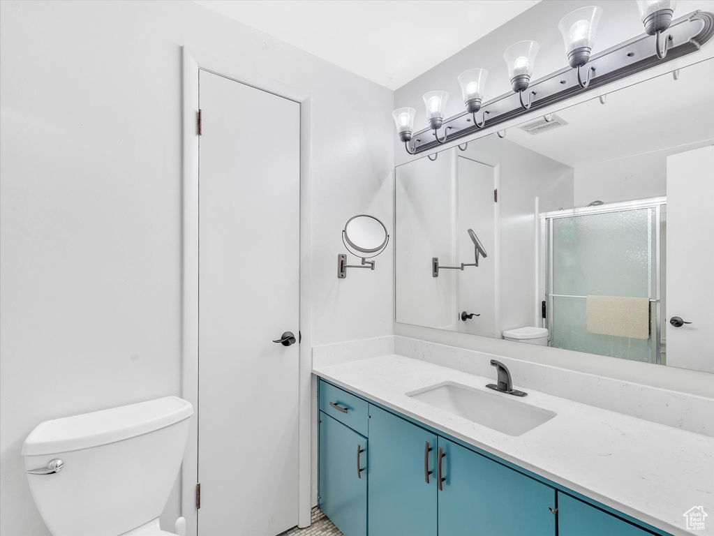 Full bathroom with toilet, vanity, and a stall shower