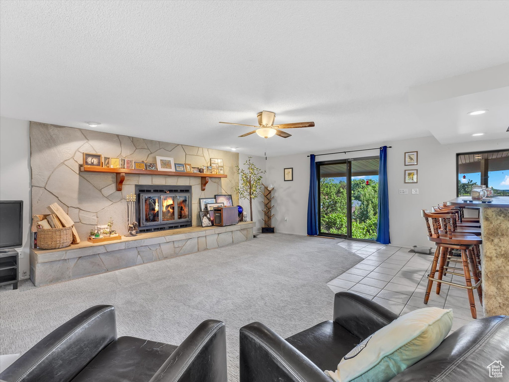 Living area with a tiled fireplace, a ceiling fan, recessed lighting, and tile patterned flooring