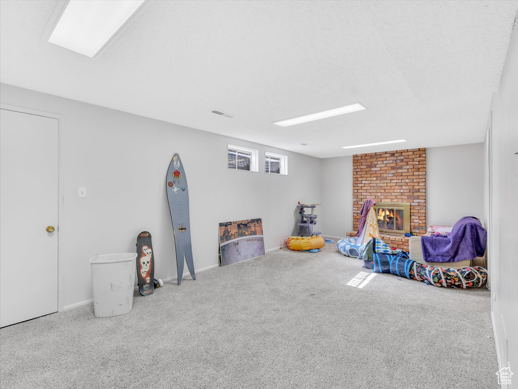 Rec room with carpet, a fireplace, and baseboards