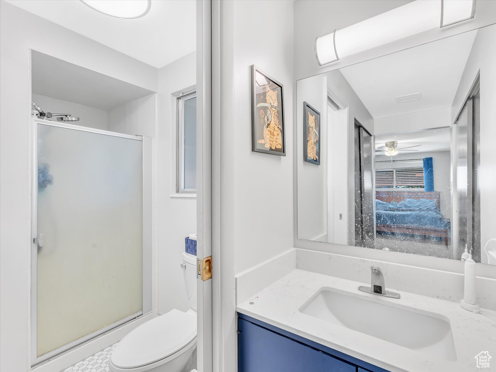 Full bath with a shower stall, vanity, toilet, and a ceiling fan