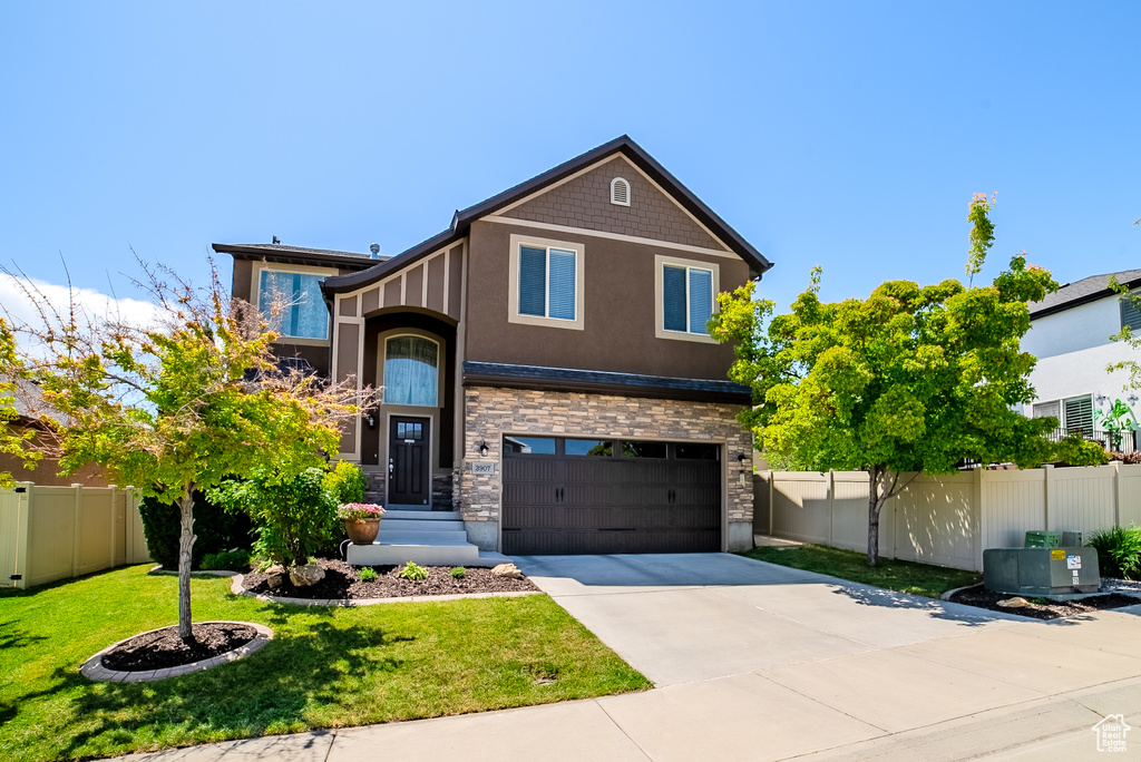 View of front of home featuring a garage, stucco siding, concrete driveway, and stone siding