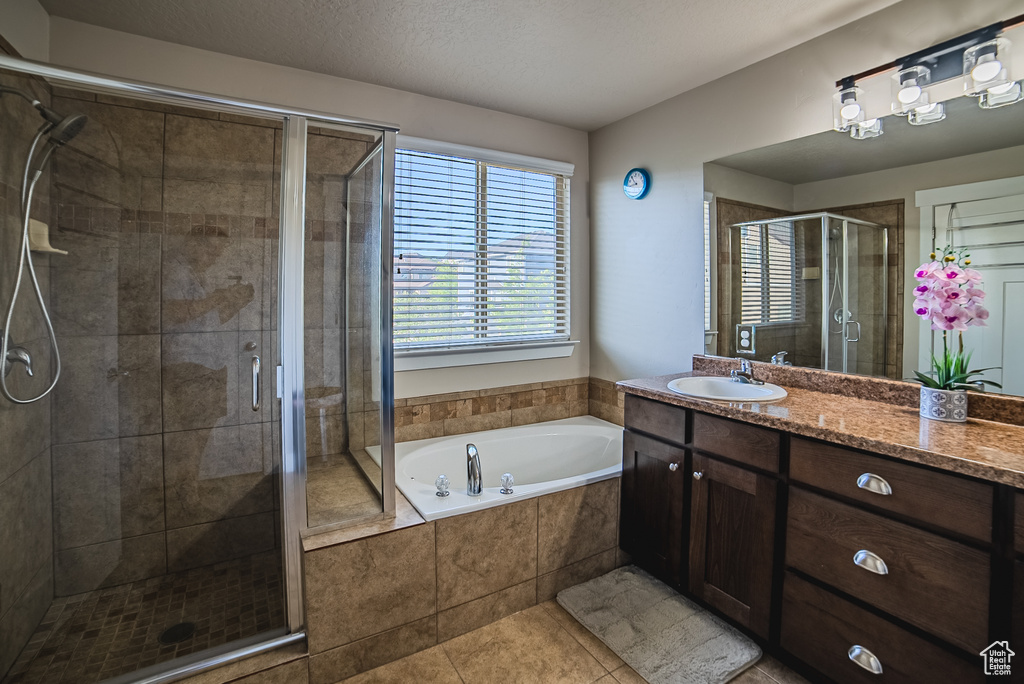 Full bathroom featuring vanity, a stall shower, a bath, and tile patterned floors
