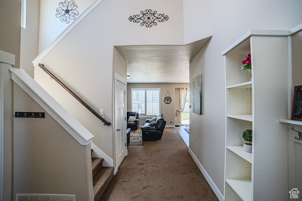 Corridor featuring stairs, carpet flooring, and baseboards