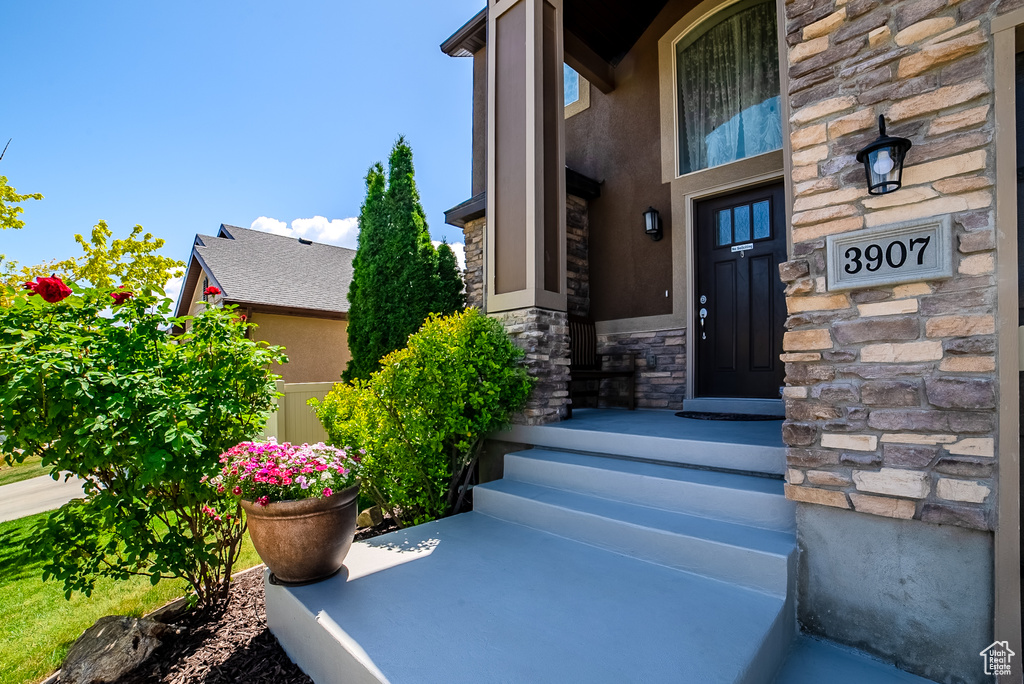 View of exterior entry featuring stone siding and stucco siding
