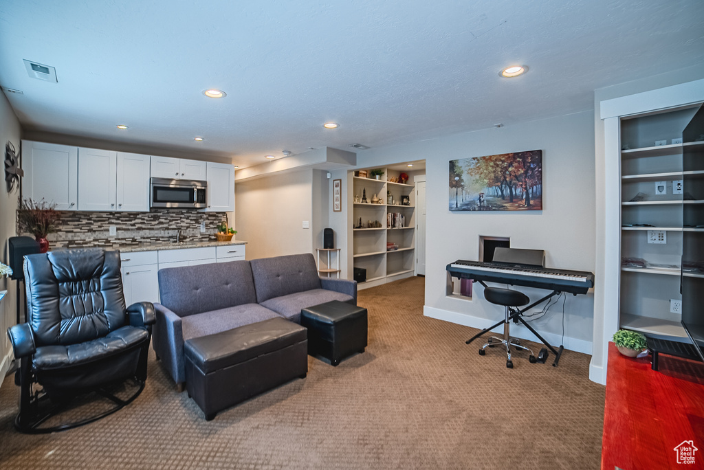 Living area with carpet, baseboards, a desk, and recessed lighting