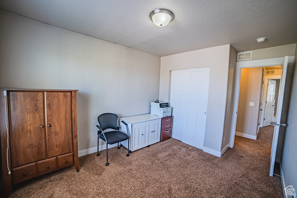 Carpeted bedroom with baseboards and a textured ceiling