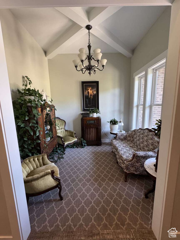 Sitting room with a chandelier, beamed ceiling, and dark carpet