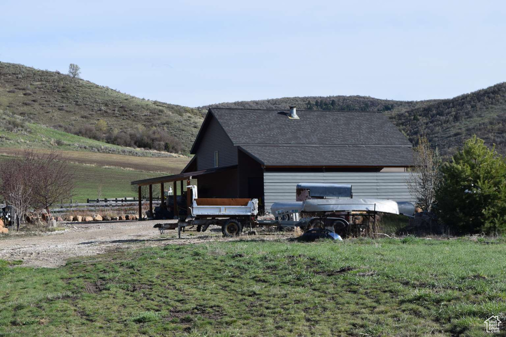 Rear view of property featuring a mountain view and roof with shingles