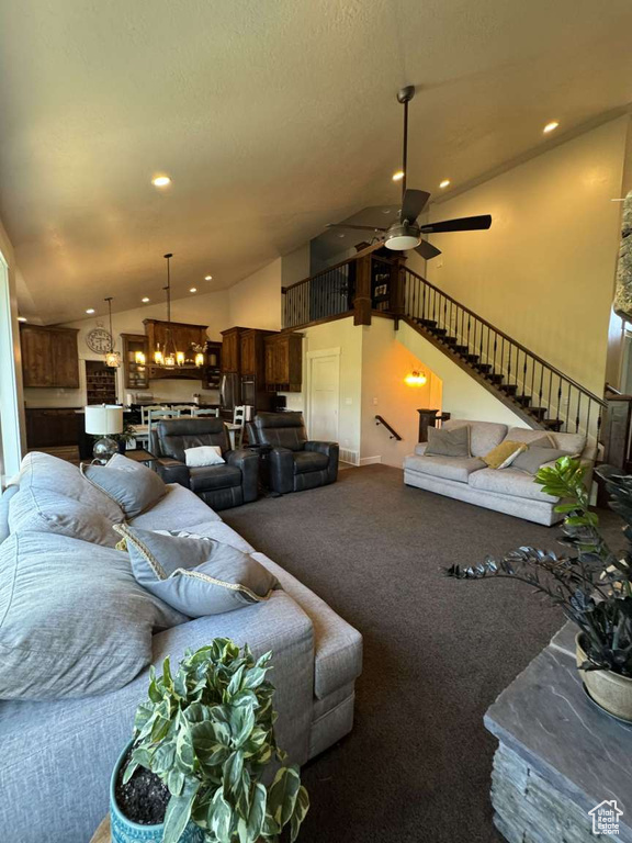 Carpeted living room with vaulted ceiling, stairway, ceiling fan, and recessed lighting
