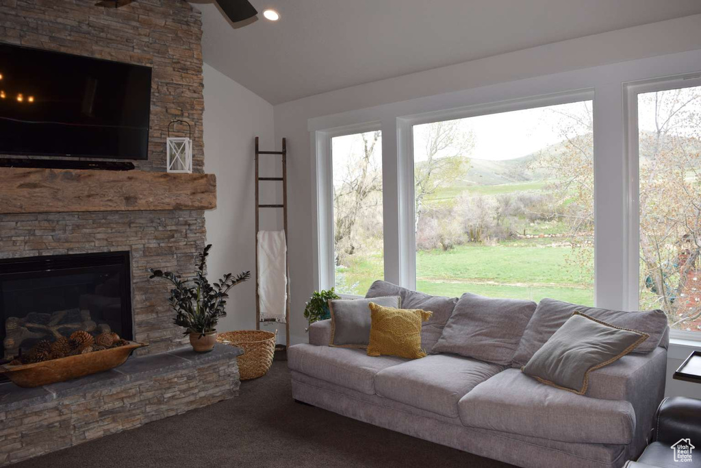 Living room with a fireplace, lofted ceiling, carpet floors, and ceiling fan