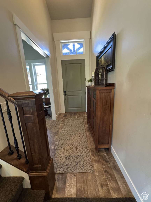 Entrance foyer with dark wood finished floors, baseboards, and stairs