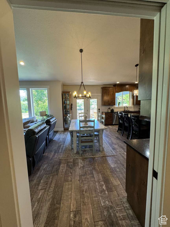 Dining space with dark wood-type flooring, a chandelier, and recessed lighting