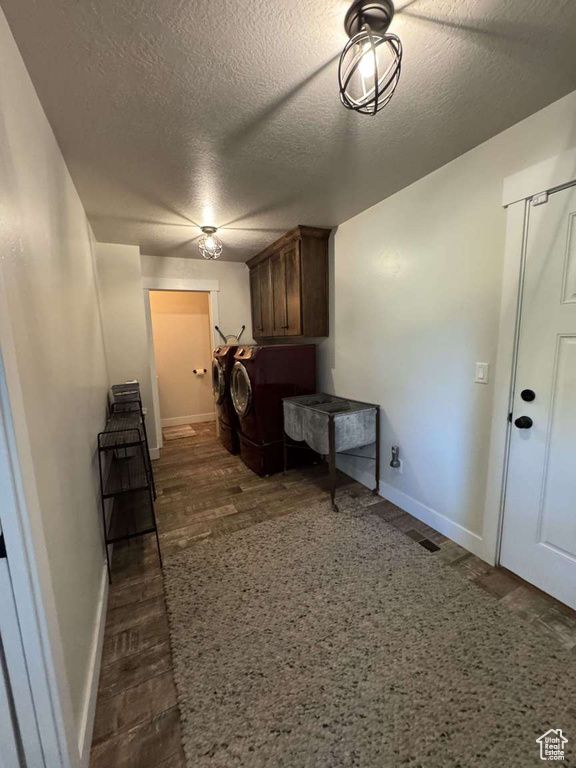 Laundry area featuring cabinet space, baseboards, and a textured ceiling