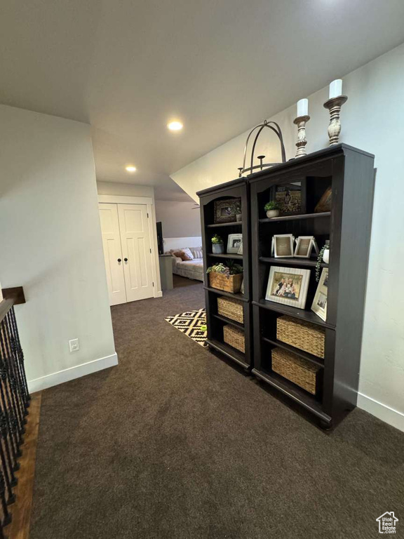 Hall featuring baseboards, dark colored carpet, and recessed lighting