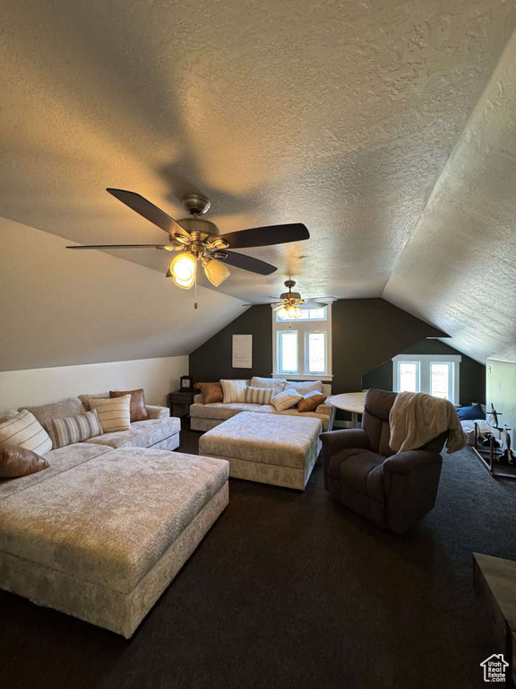 Bedroom featuring a textured ceiling, lofted ceiling, carpet, and ceiling fan
