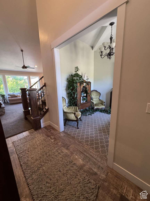 Hall featuring stairs, carpet, a chandelier, and baseboards