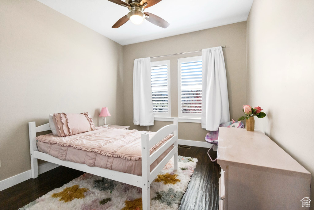 Bedroom with baseboards, wood finished floors, and ceiling fan