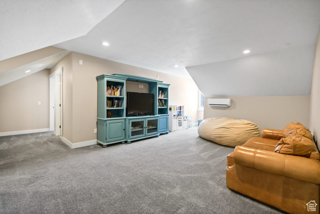 Living room with carpet, recessed lighting, a wall mounted air conditioner, baseboards, and vaulted ceiling