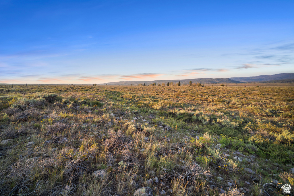 Nature at dusk featuring a mountain view and a rural view
