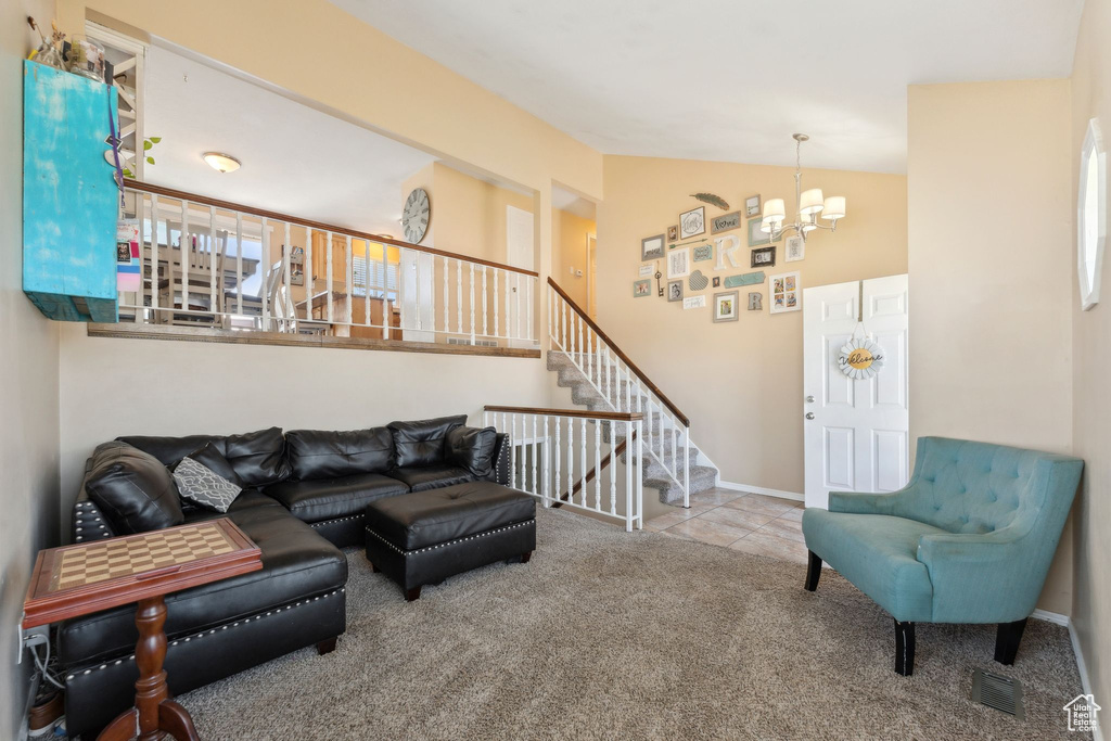 Carpeted living area featuring a chandelier, stairway, vaulted ceiling, and baseboards