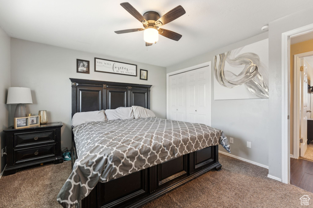 Carpeted bedroom with a closet, ceiling fan, and baseboards