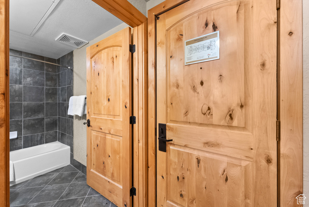 Full bath featuring tile patterned flooring and shower / bathtub combination