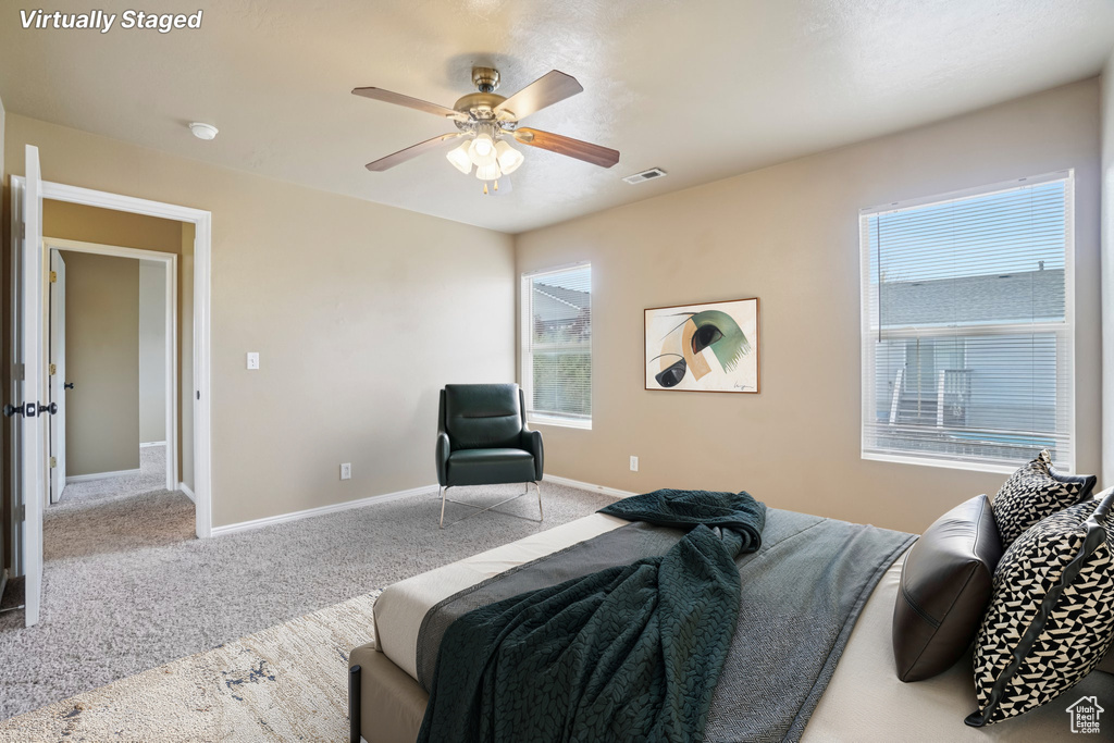 Carpeted bedroom featuring multiple windows, baseboards, and a ceiling fan