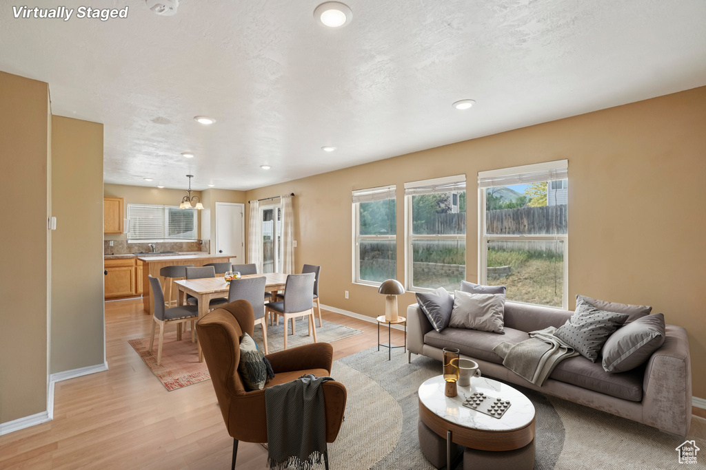 Living area with light wood-style floors, baseboards, and recessed lighting