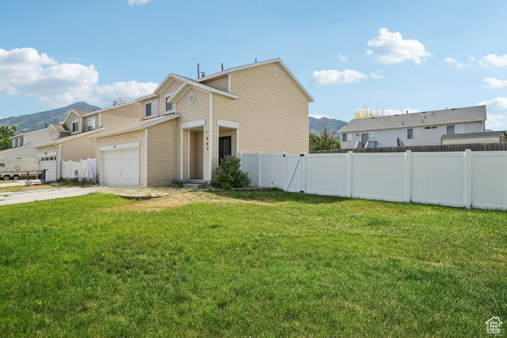 View of front of house with concrete driveway, a garage, and a mountain view