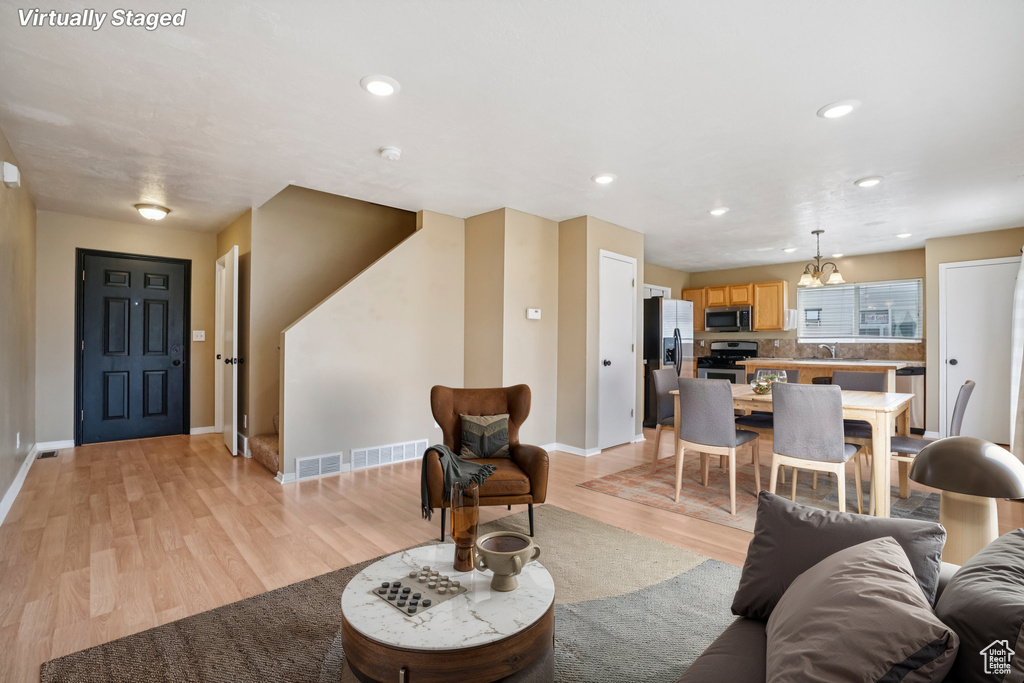 Living room featuring light wood-style flooring, baseboards, and recessed lighting