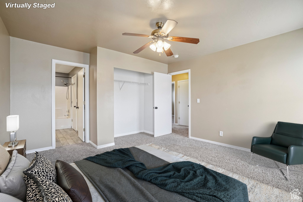 Bedroom featuring light carpet, baseboards, a closet, ensuite bathroom, and ceiling fan