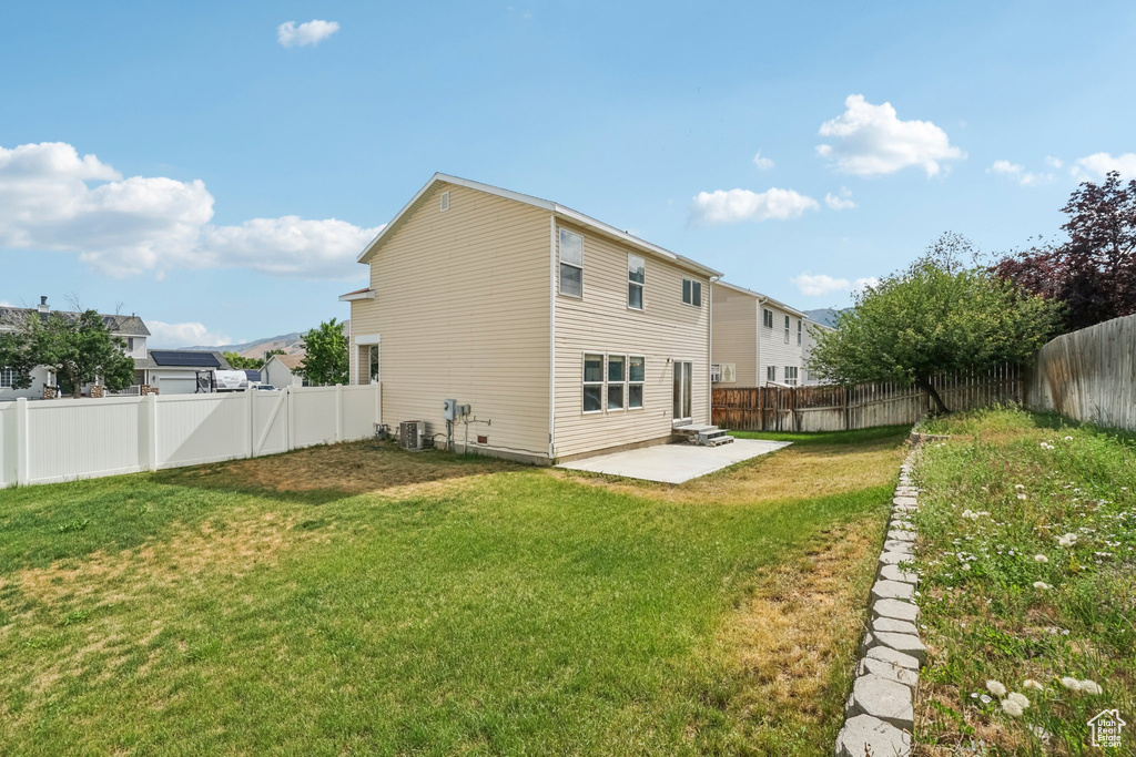Back of property with a patio and central AC unit
