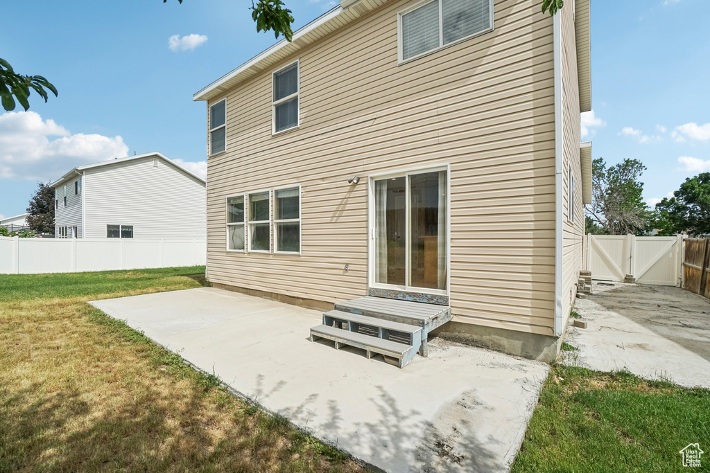 Back of property with a patio and a gate