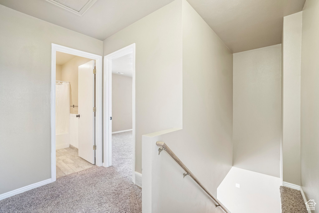 Corridor with an upstairs landing, carpet, and baseboards
