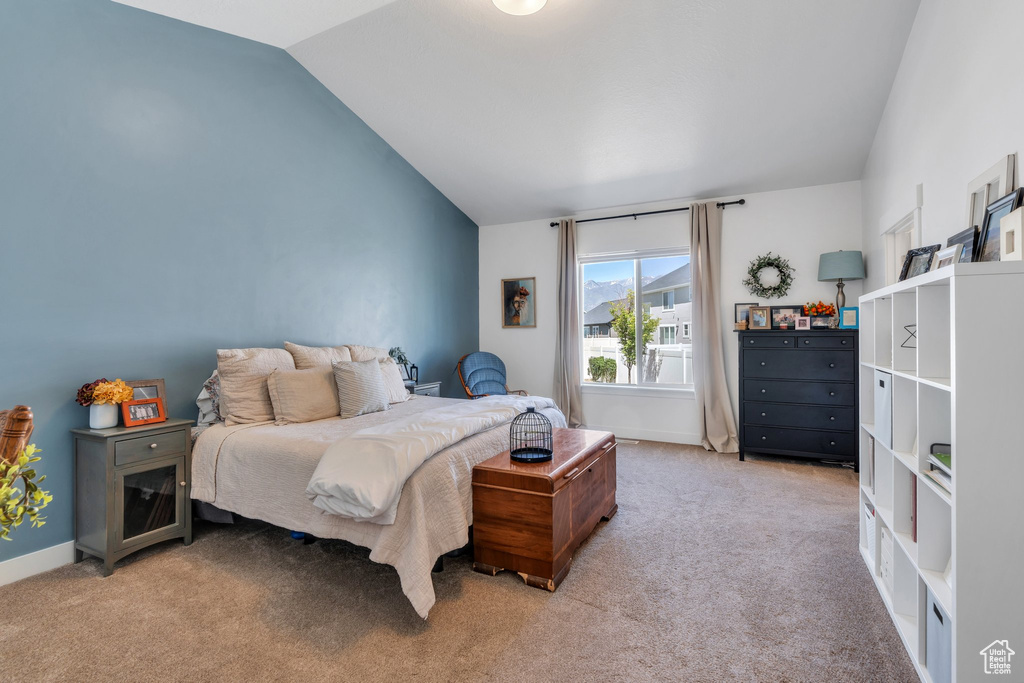 Bedroom featuring lofted ceiling, carpet floors, and baseboards